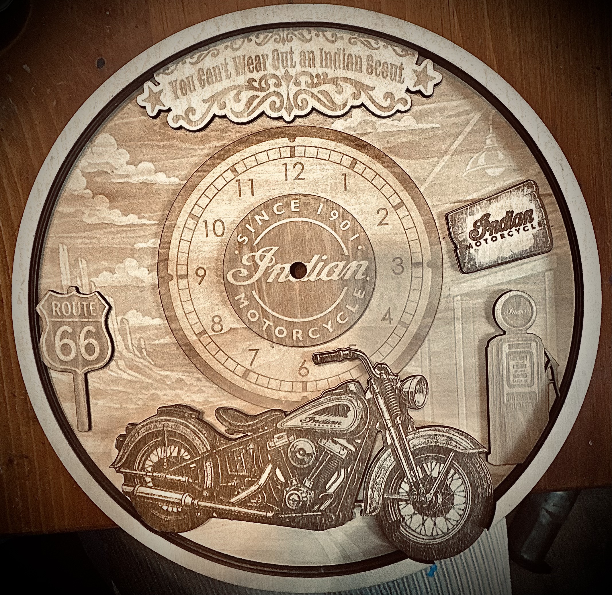 Laser-engraved wooden Indian Motorcycle clock face with Route 66 sign, vintage motorcycle, gas station, and 'You Can't Wear Out an Indian Scout' banner