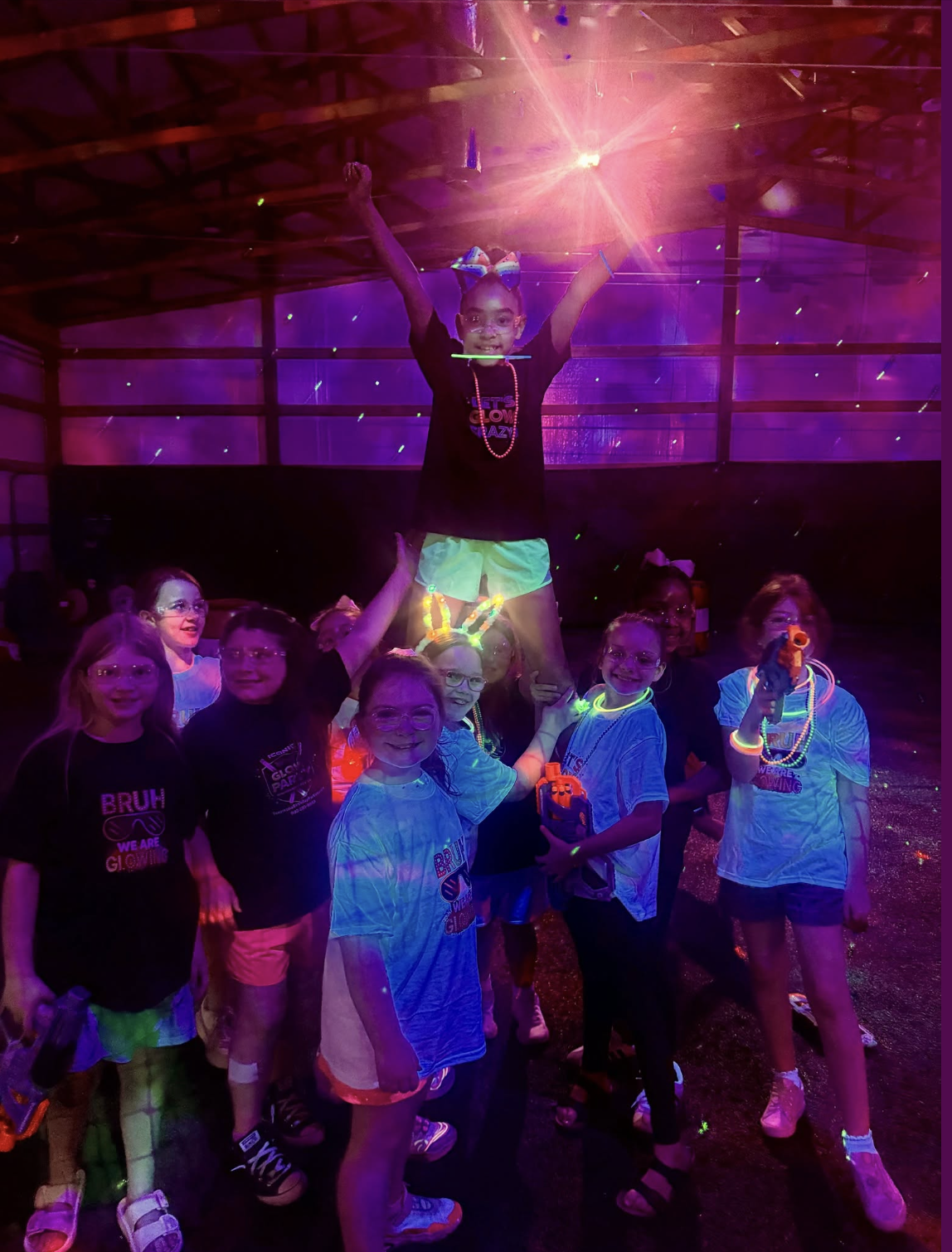 Kids group photo at glow party with black lights and glow shirts in Texarkana - Iconic Performance Center