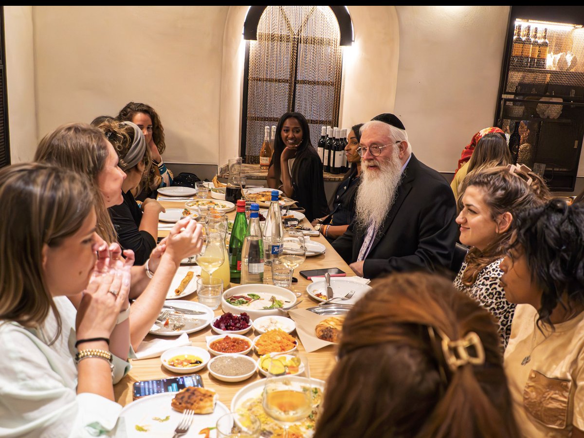 Rabbi Mentz seated with the widows and community at dinner