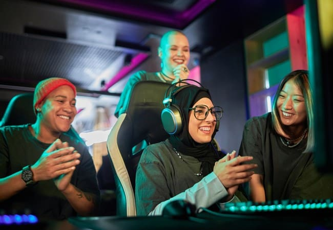 Diverse group of women celebrating together at a gaming setup