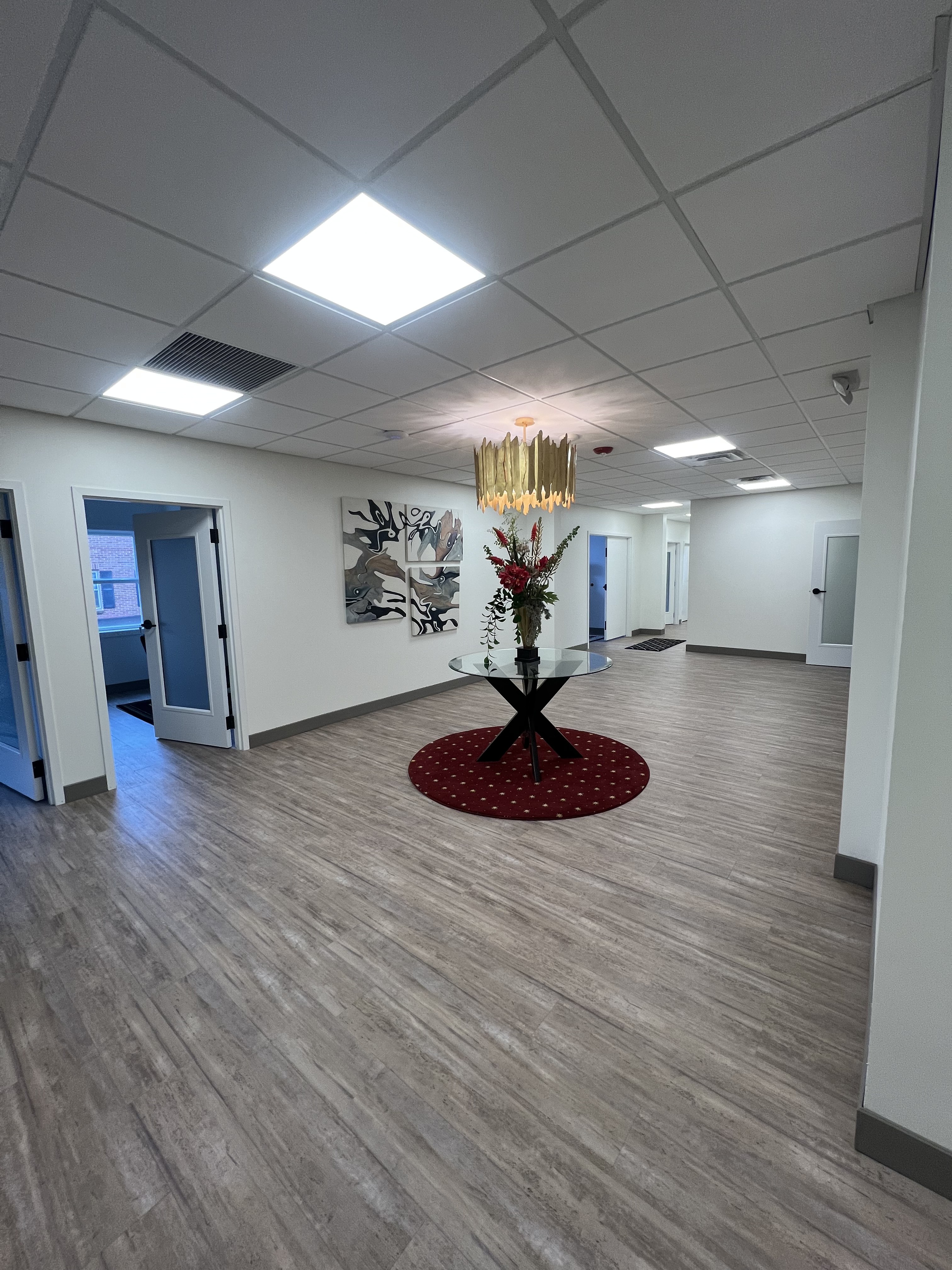 Completed commercial office lobby with LED panel lights and decorative chandelier installed by Premier Alarms and Electric โ Rochester NY