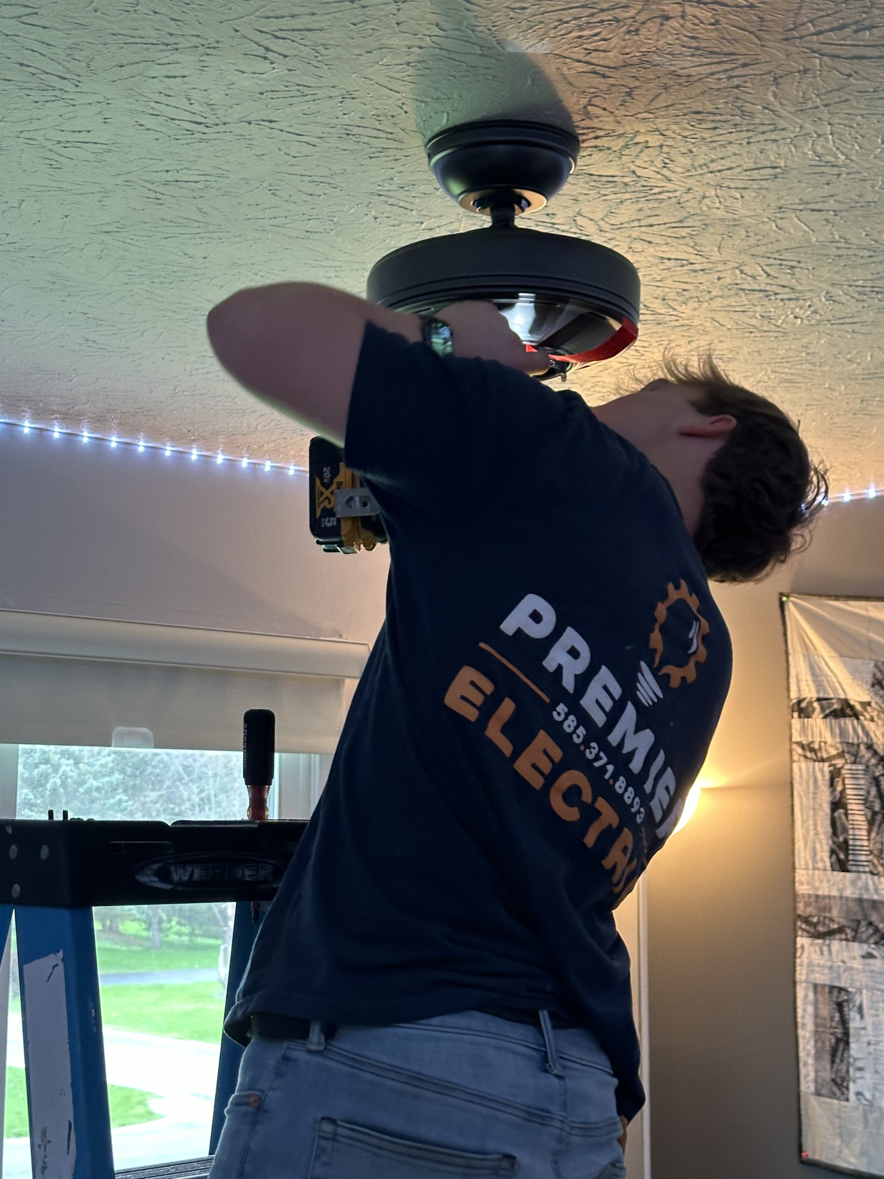 Premier Alarms and Electric technician installing ceiling fan in residential home, Monroe County NY