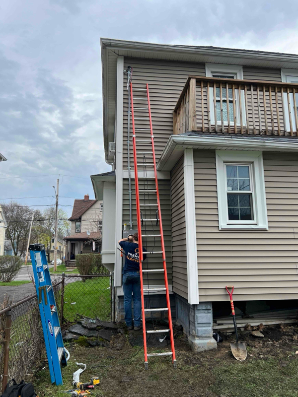Premier Electric crew on ladder exterior residential electrical service work Rochester NY