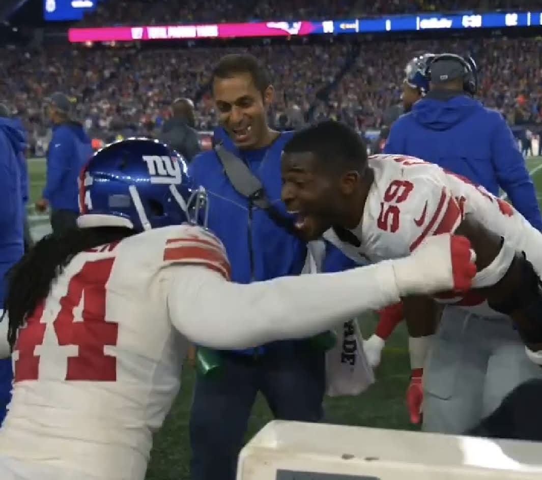 Pratik Patel celebrating with New York Giants players on the sideline
