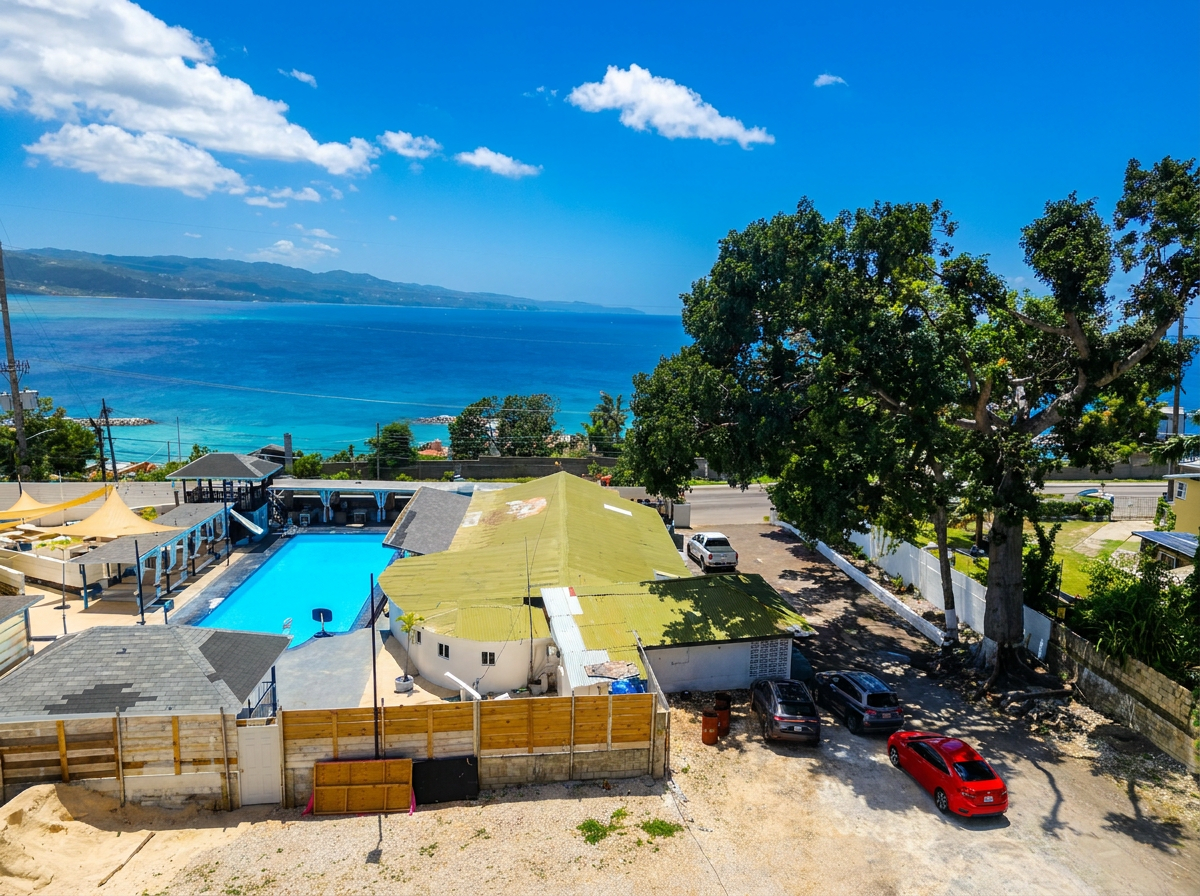MG10 elevated view — turquoise Caribbean Sea, pool, parking, tropical landscape from Montego Gardens