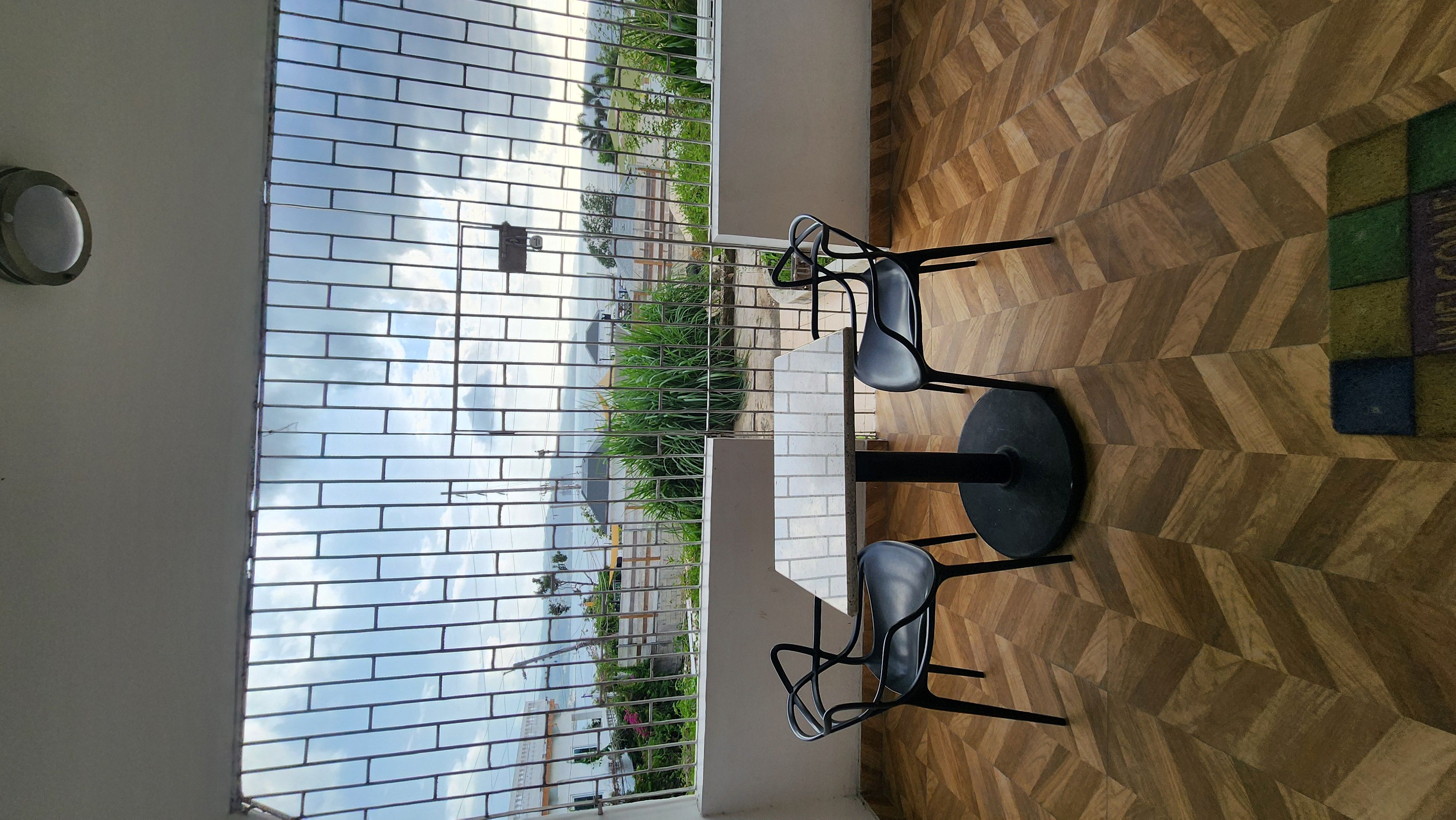 MG6 indoor dining area with view through open balcony window to sky and greenery