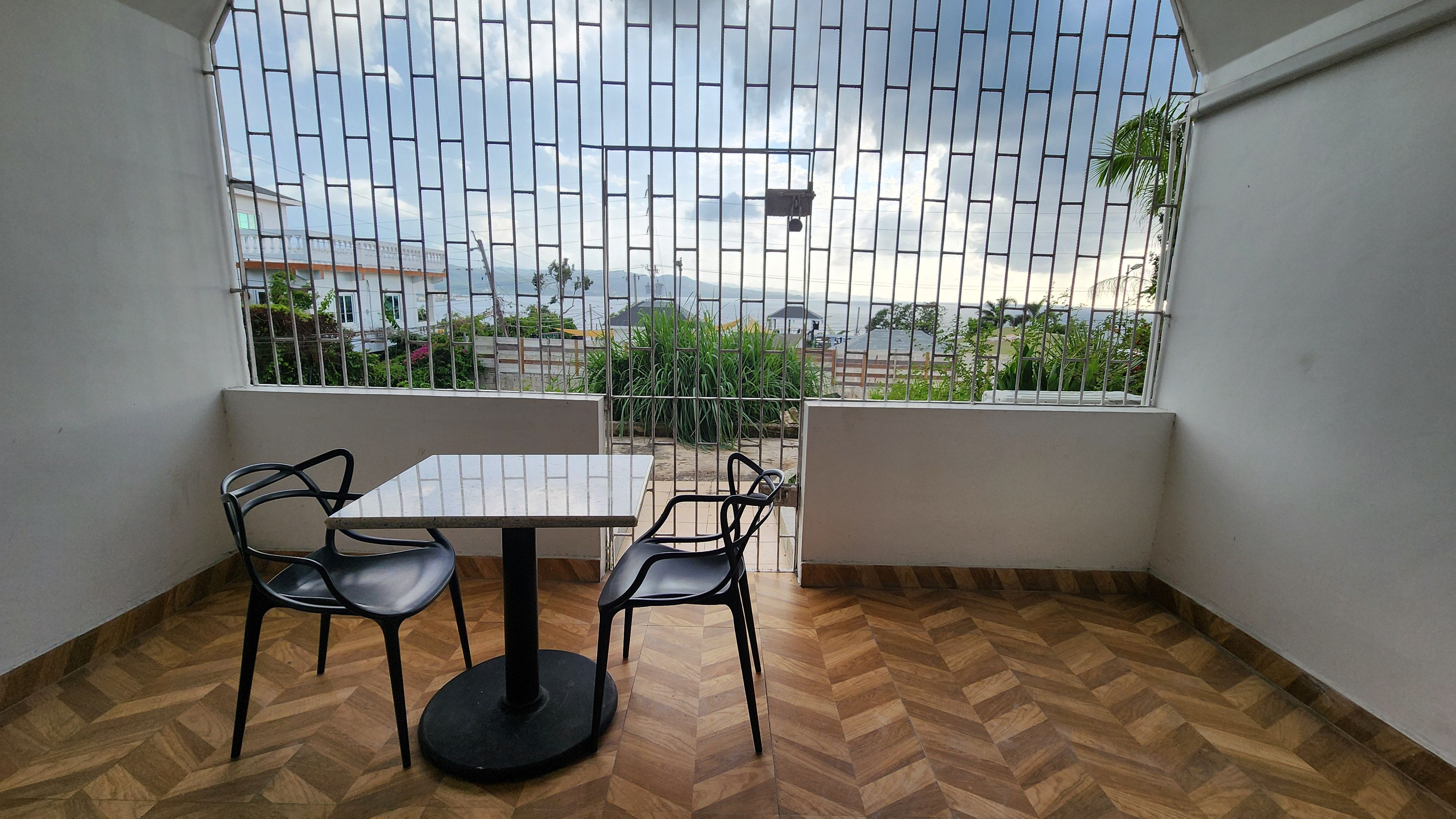 MG6 private balcony with table and chairs overlooking ocean and tropical garden