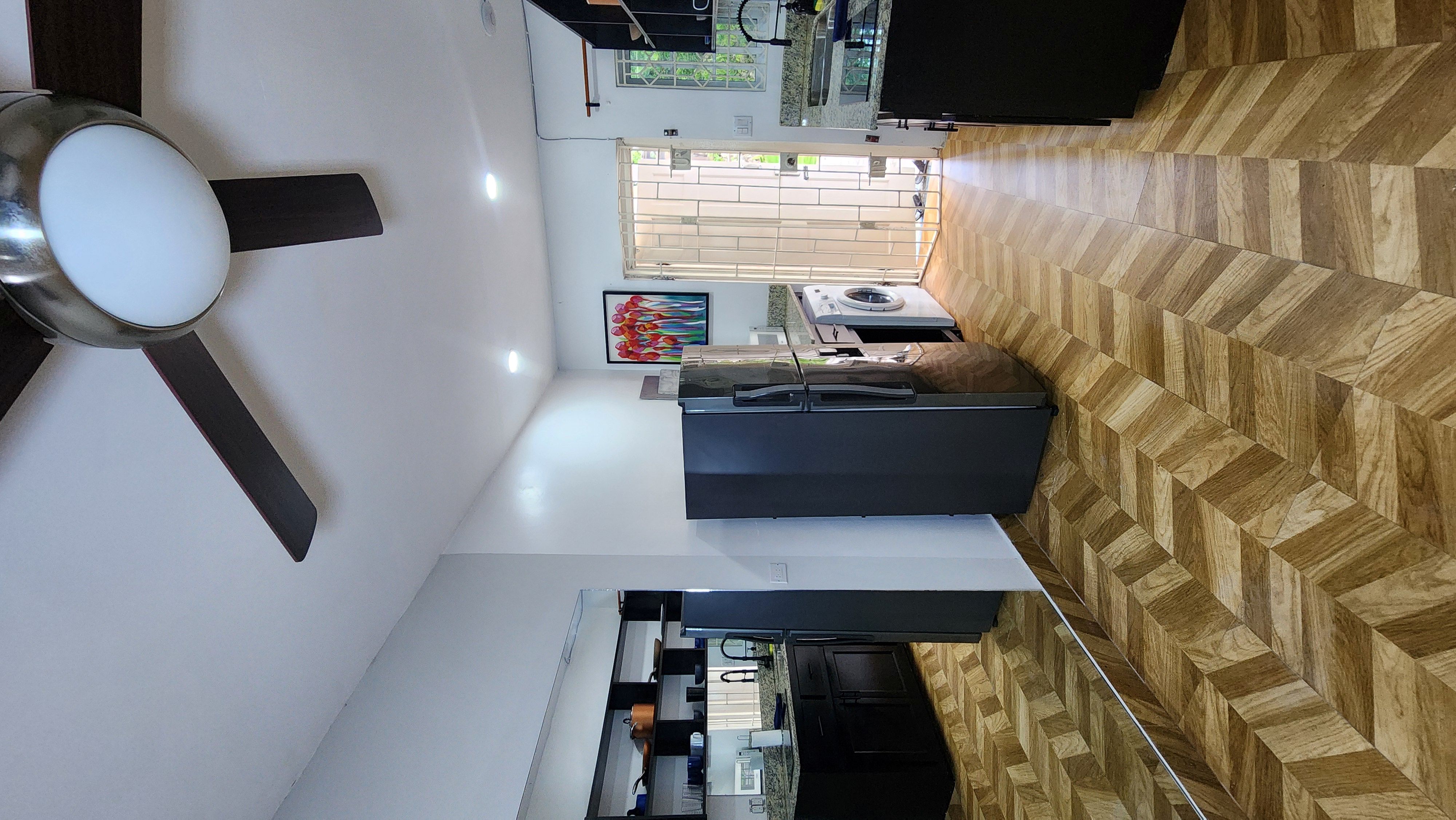 MG6 full kitchen with fridge, washer, Smart TV, Jamaican artwork, and balcony access
