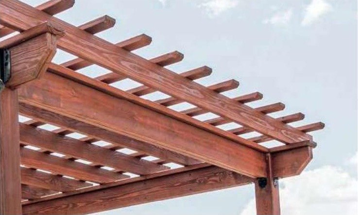 Low-profile rafters and purlins on a stained wood Hollander pergola against a blue sky