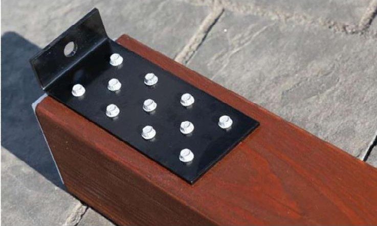 Close-up of a custom steel anchor bracket bolted to a stained wood post on a Hollander pergola