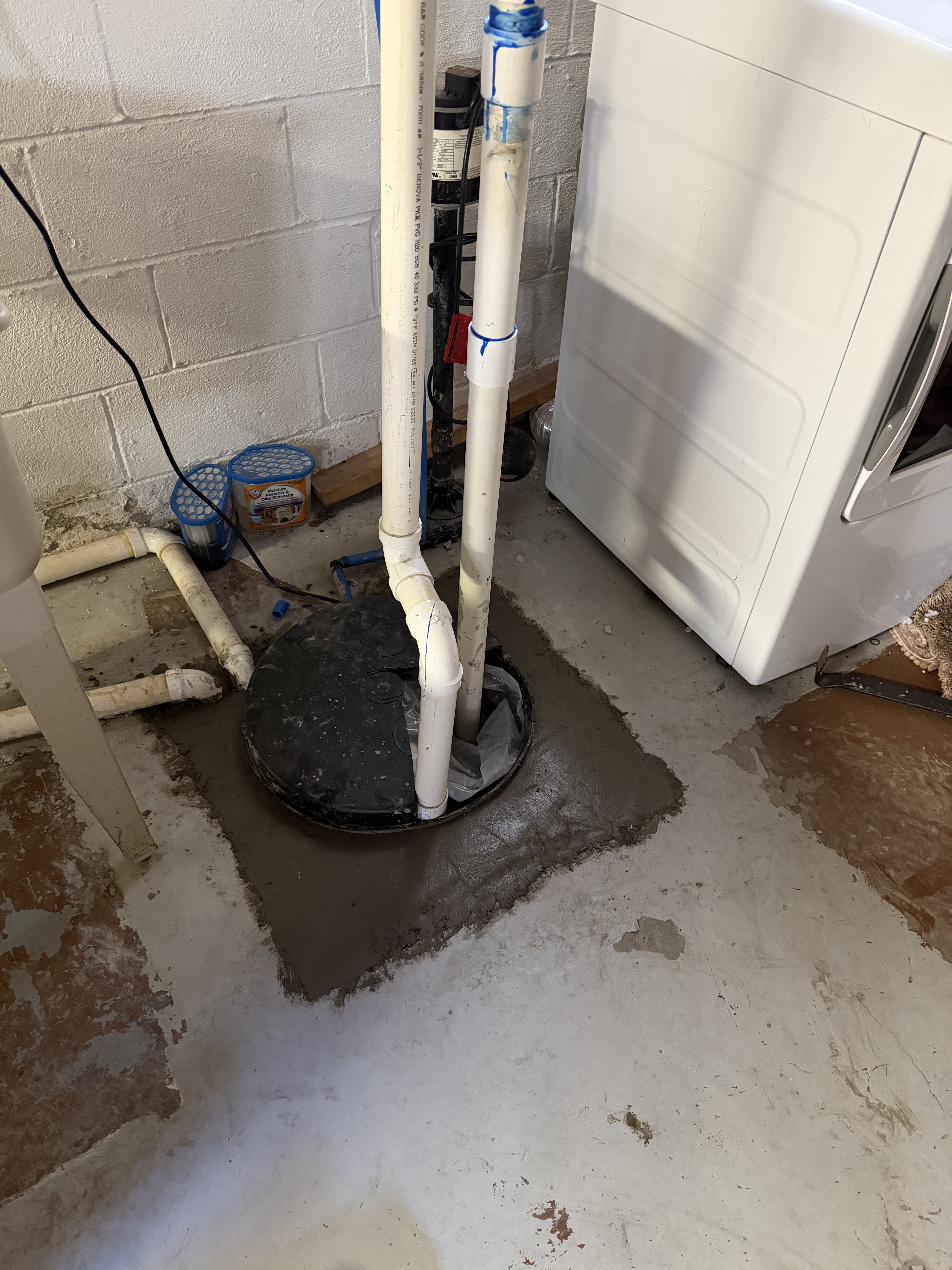 After: Sealed sump pump crock with fresh cement and proper discharge piping