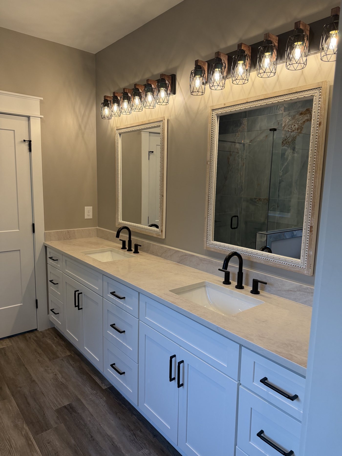 Double vanity with white shaker cabinets, stone countertop and matte black fixtures