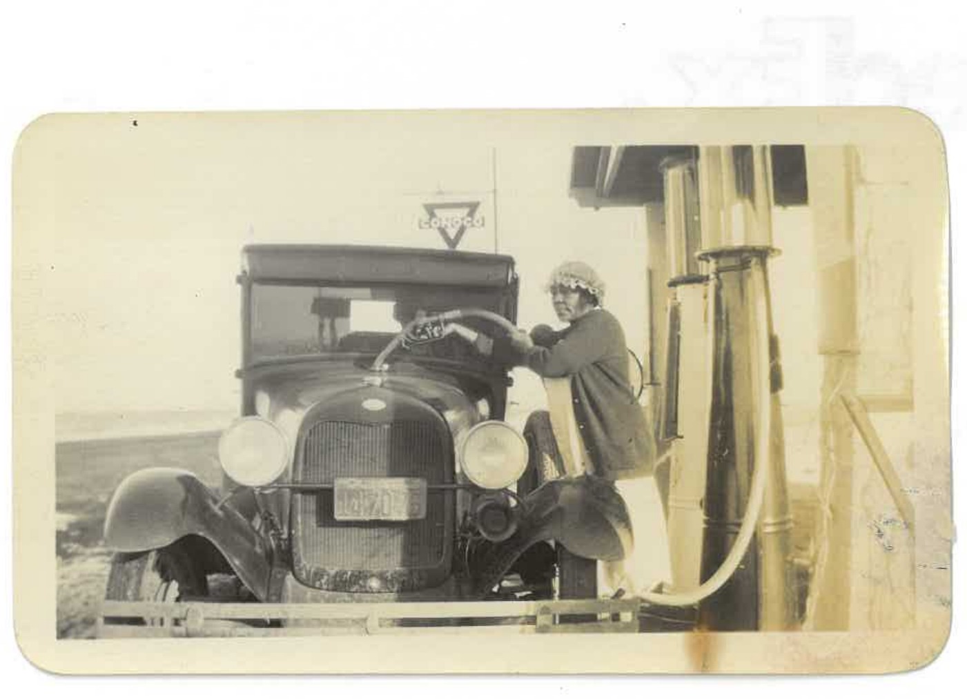 A car being fueled at the Dearfield Filling Station, c. 1920s