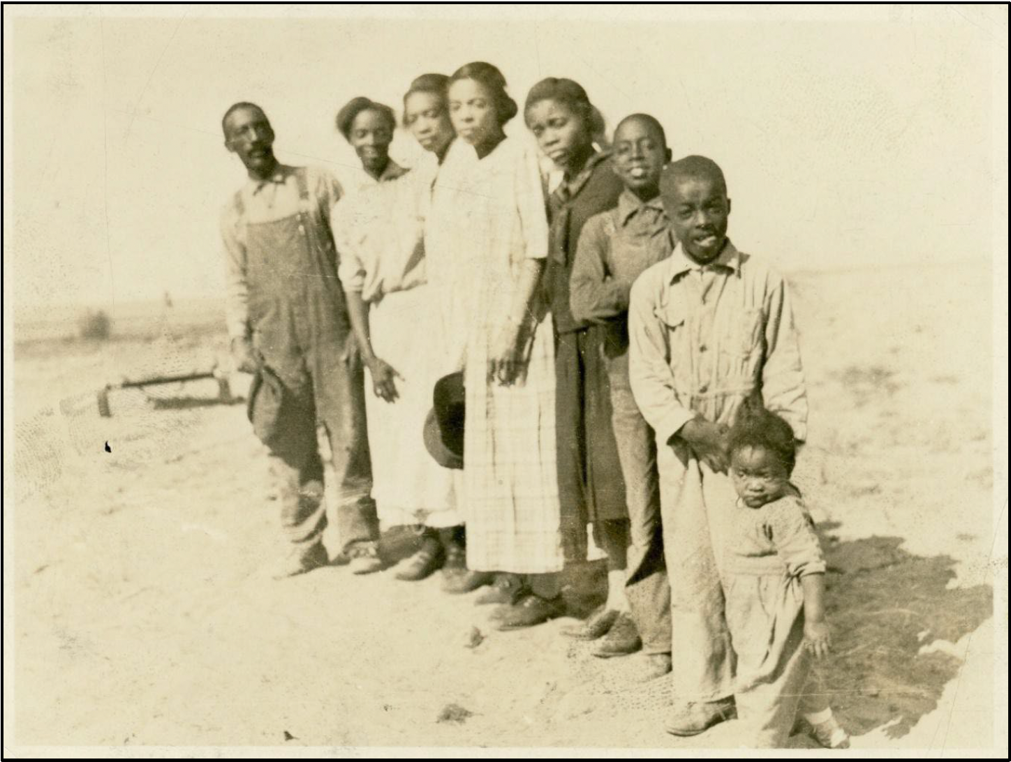 The Hicks family standing on their homestead, circa 1910s