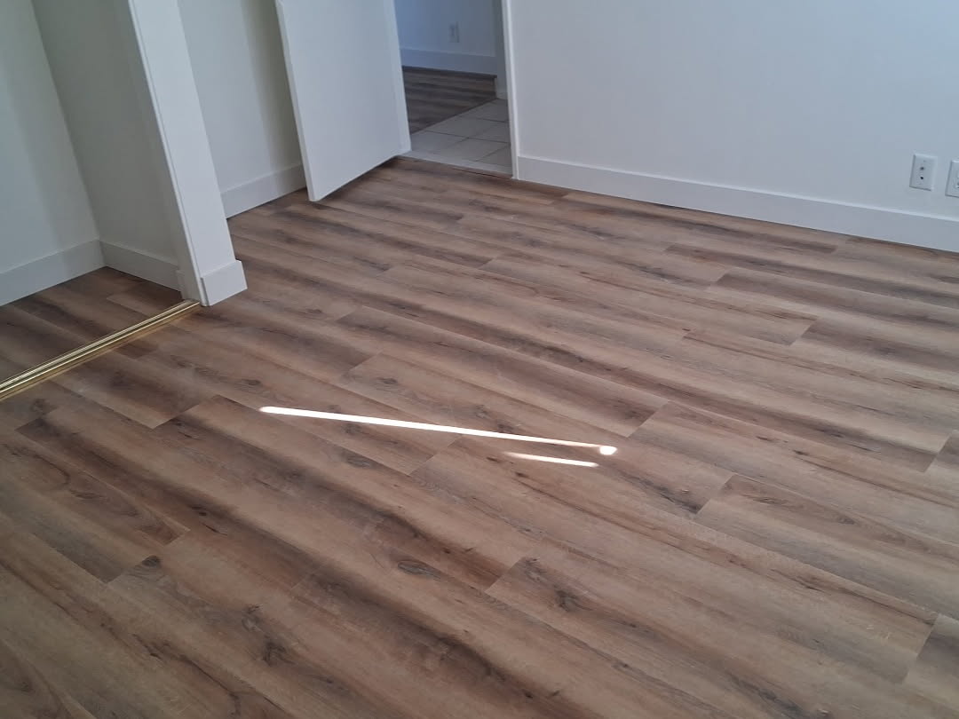 LVP flooring installed in living area with clean baseboard transitions by PMR Projects