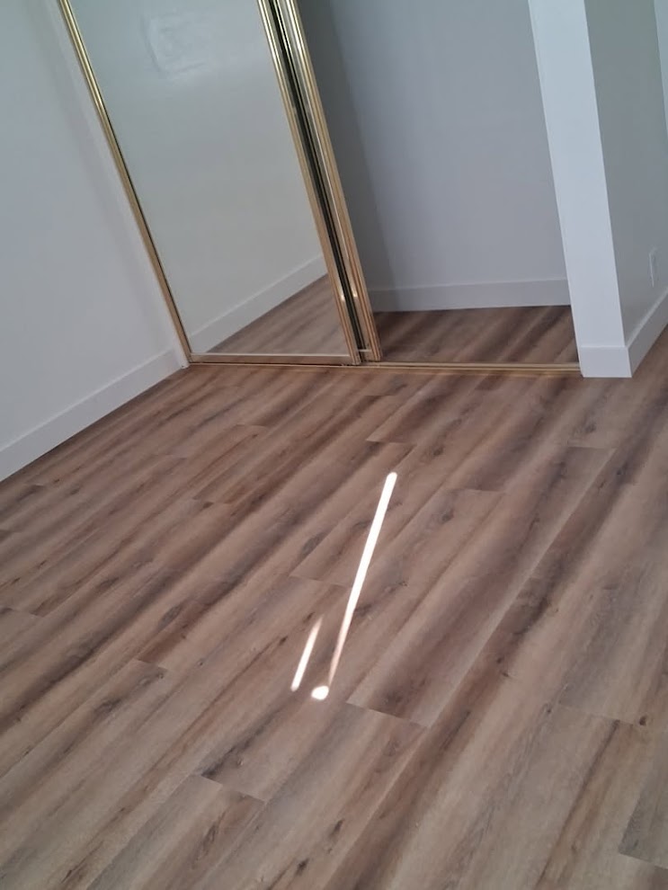 LVP flooring installed in bedroom with mirrored closet doors — clean transitions by PMR Projects